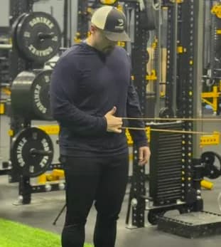 Dylan coaching a resisted shoulder exercise for a throwing athlete